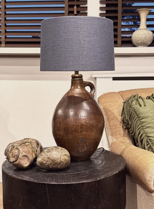 Stylowa aranżacja wnętrza prezentująca francuską lampę ceramiczną z abażurem w otoczeniu dodatków