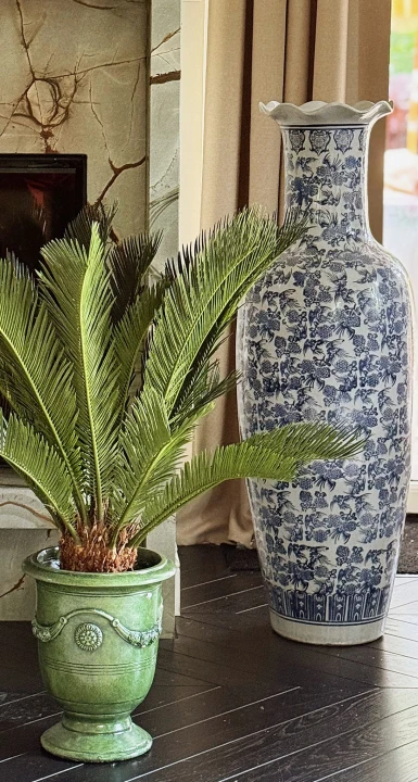 Chiński wazon ceramiczny z kobaltowym wzorem wyeksponowany we wnętrzu w otoczeniu roślin