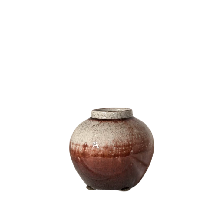 Małe czerwono-kremowe naczynie ceramiczne o pękatej formie z widocznym efektem spękań